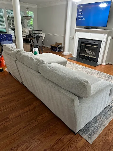 Gray couch in living room with fireplace and mounted TV