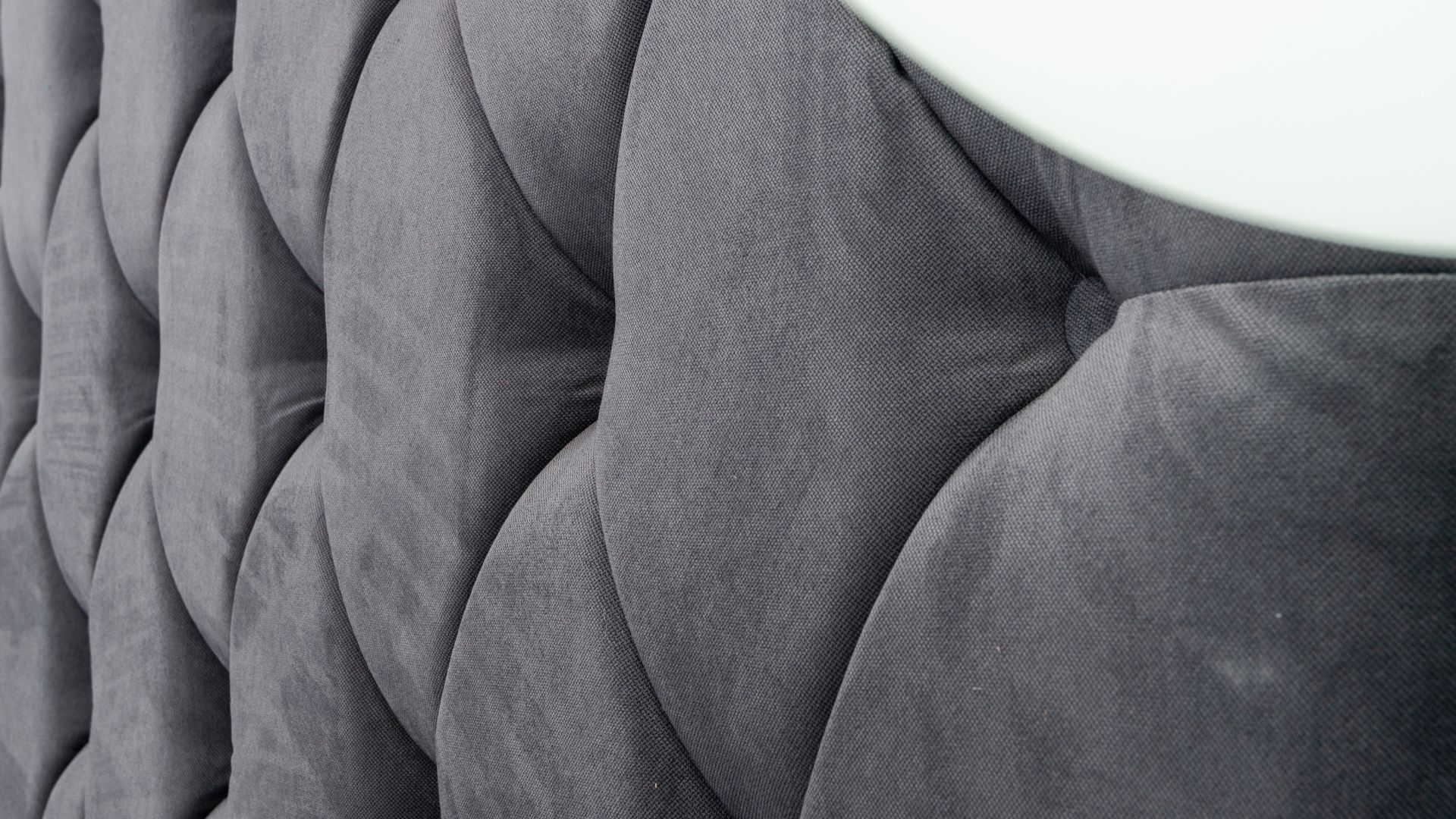 Gray textured upholstery with curved, quilted pattern and soft fabric